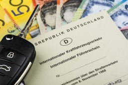 Australischer Dollar internationalem Führerschein Symbolbild. Darauf Australischer Dollar mit internationalem Führerschein