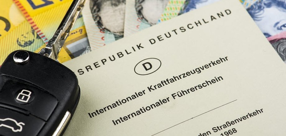Symbolbild. Darauf Australischer Dollar mit internationalem Führerschein