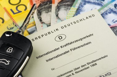 Symbolbild. Darauf Australischer Dollar mit internationalem Führerschein