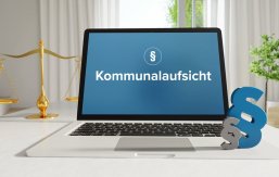 Kommunalaufsicht – Recht, Gesetz, Internet. Laptop im Büro mit Begriff auf dem Monitor. Paragraf und Waage. Kommunalaufsicht – Recht, Gesetz, Internet. Laptop im Büro mit Begriff auf dem Monitor. Paragraf und Waage.