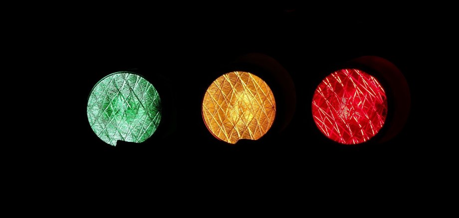 Eine Ampel, an der das rote, das gelbe und das grüne Licht brennen