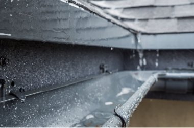 Jets of rain drain into the drainage system on the roof of the house