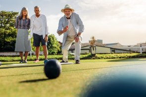 Group of senior people playing boules in a lawn Group of senior people playing boules in a lawn