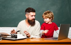 Concept of education and teaching. Teacher helping pupils studying on desks in classroom. Copy space. Elementary school. Young or adult. Dad son are concentrated on the problem. Concept of education and teaching. Teacher helping pupils studying on desks in classroom. Copy space. Elementary school. Young or adult. Dad son are concentrated on the problem.