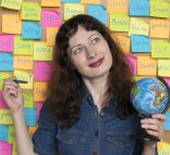 Studying languages concept, pretty young woman next to the wall with many greetings in different languages. Studying languages concept, pretty young woman next to the wall with many greetings in different languages.