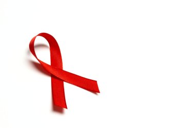 Red ribbon as symbol of aids awareness on white background with