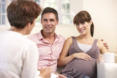 Hebamme - Expectant couple talking to midwife