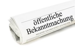 öffentliche Bekanntmachung Zusammengerollte Zeitung darauf ist Öffentliche Bekanntmachung zu lesen