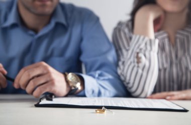 Couple with divorce contract and ring on desk. Divorce