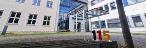 Eingangsbereich der Kreisverwaltung. im Vordergrund ist eine Sitzbank zu sehen.