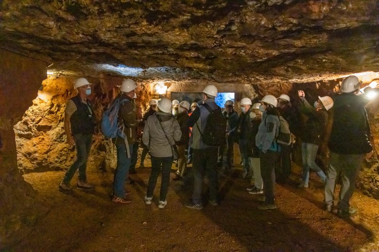Eine Exkursionsstation war der Gewölbekeller unter der Stadt Herbstein. Menschen bei einer Führung im Gewölbekeller. Sie tragen weiße Schutzhelme.