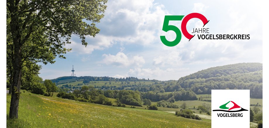 Ein Panoramabild mit Blick auf den Fernsehturm auf dem Hoherodskopf. Im Vordergrund sind Bäume und grüne Wiesen zu sehen