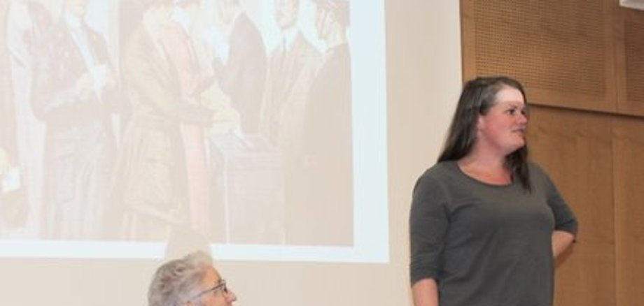 Kreisbeigeordnete Stephanie Kötschau (stehend) in Jeans und grauem OBerteil begrüßte die Sozialwissenschaftlerin Dr. Elke Schüller aus Frankfurt. Sie sitzt in einem Stuhl. Sie ordnete in ihrem Vortrag die Geschichte des Frauenwahlrechts ein. 1918 – vor 100 Jahren – wurde das Frauenwahlrecht in Deutschland eingeführt. Fotos: Erich Ruhl-Bady