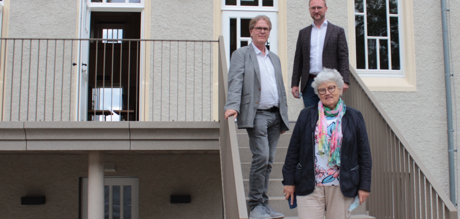 Gruppenbild auf einer Treppe: Erster Kreisbeigeordneter Dr. Jens Mischak (CDU, hinten rechts), gemeinsam mit Gerhild Hoos-Jacob, der neuen Vorsitzenden des Jugendhilfeausschusses gemeinsam mit Helmut Benner, stellvertretender Leiter des Jugendamtes des Vogelsbergkreises.