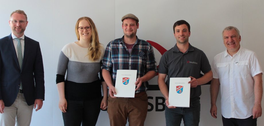 Erster Kreisbeigeordneter Dr. Jens Mischak (links) und Peter Sukdolak vom Sachgebiet Dorf- und Regionalentwicklung (rechts) übergeben Luisa und Jan Becker sowie Oliver Raatz Zuwendungsbescheide. 
