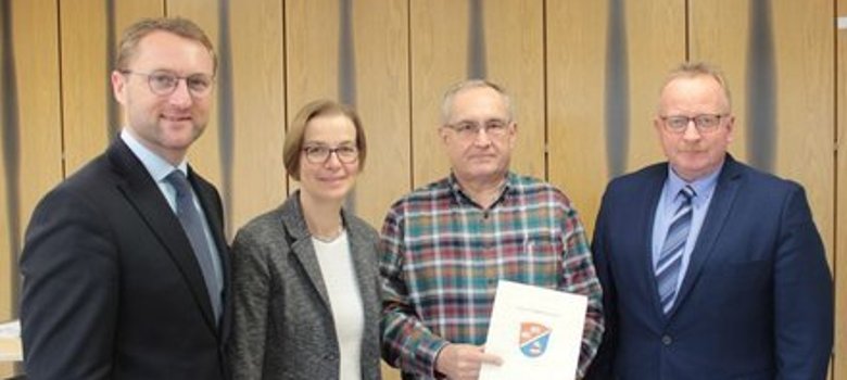 Bürgermeister Dieter Schäfer (von rechts) und Reiner Seibert vom Verein Nachbarschaftshilfe Lautertal erhalten aus den Händen von Angelika Boese und Erstem Kreisbeigeordnetem Dr. Jens Mischak den Förderbescheid.