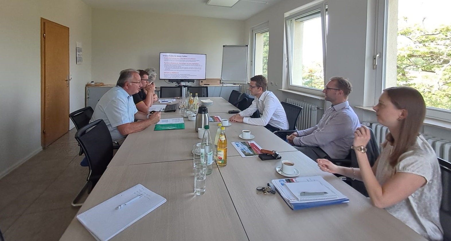 Landrat Dr. Jens Mischak und Staatssekretär Michael Ruhl im Gespräch mit den Fachleuten des Amtes für Wirtschaft und den ländlichen Raum in Lauterbach. Sie sitzen gemeinsam an einem langen Tisch.