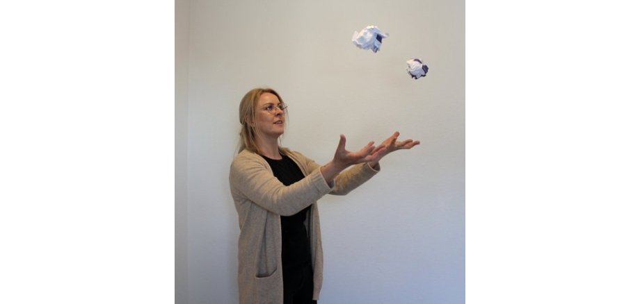 Frau jongliert mit Papierkugeln