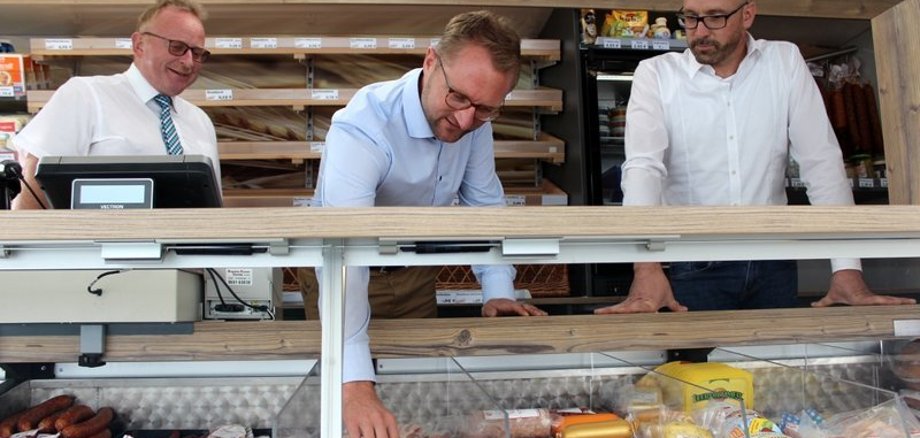 Wirtschaftsdezernent Mischak (Mitte) greift zur Gulaschsuppe in Wurstform - nur eine von vielen Spezialitäten, die Verkaufsfahrer Heiko Schäfer (rechts) in seinem Sortiment hat. Auch Lautertals Bürgermeister Dieter Schäfer schaut sich den neuen Verkaufswagen genauer an. 