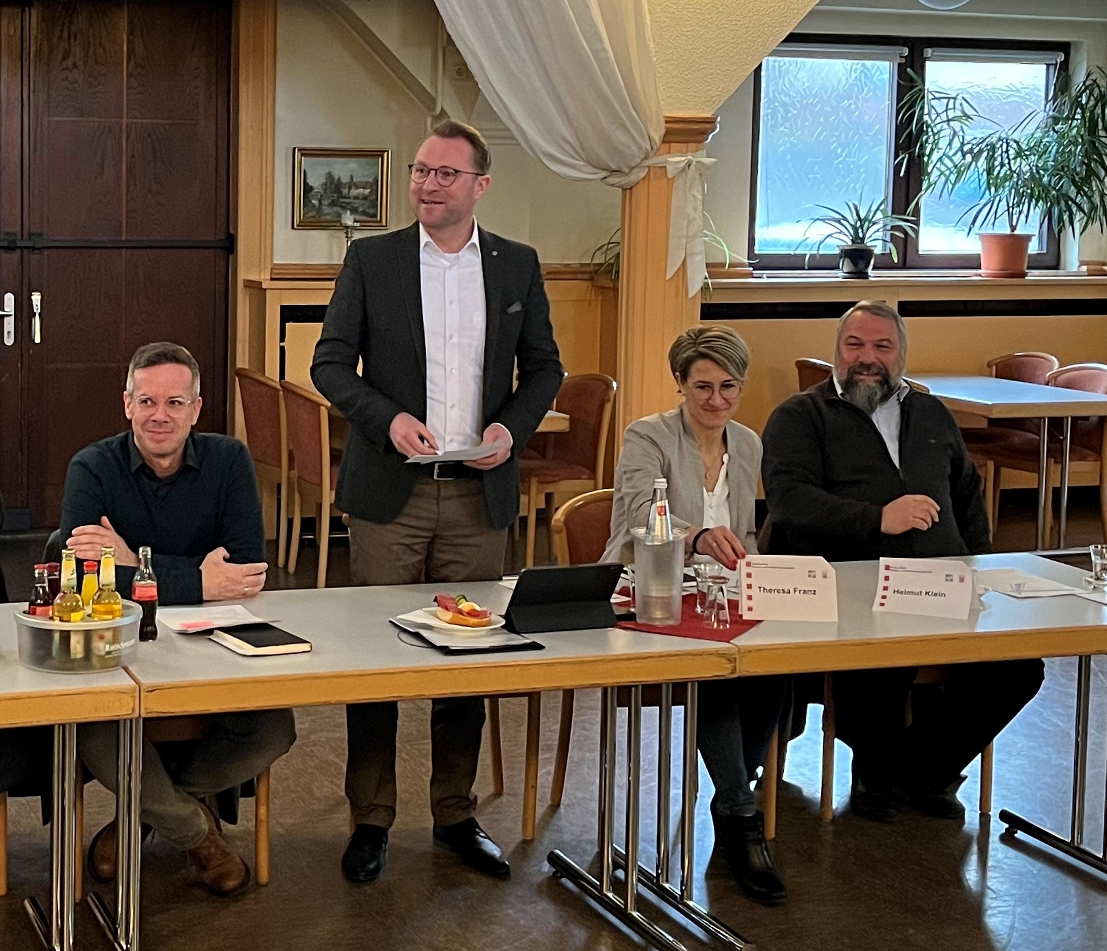 Erster Kreisbeigeordneter und Verkehrsdezernent Dr. Jens Mischak (stehend) begrüßt die Bürgermeisterinnen und Bürgermeister der Städte und Gemeinden des Vogelsbergkreises sowie die Mitarbeiterinnen und Mitarbeiter von Hessen Mobil zur Vorstellung der Straßenbaumaßnahmen im Kreis. Mit dabei sind auch Helmut Klein, Dezernent für Planung und Bau von Hessen Mobil, Theresa Franz, Fachdezernentin Ingenieurbauwerke, sowie Stefan Günther, Leiter des Sachgebiets Kreisstraßen beim Vogelsbergkreis (von rechts). 