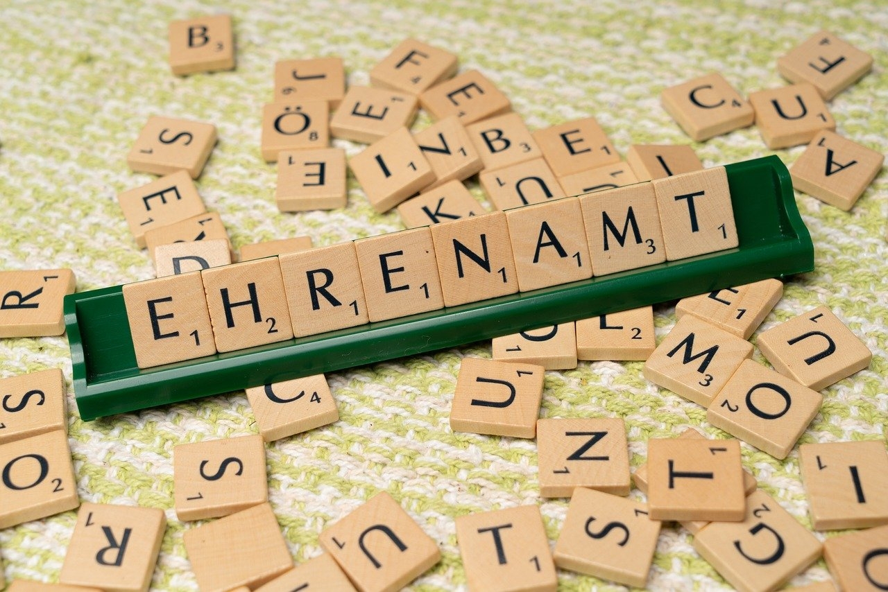 Das Wort "Ehrenamt" gelegt mit Scrabblesteinen aus Holz