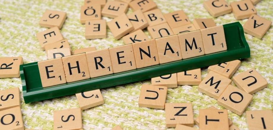 Das Wort "Ehrenamt" gelegt mit Scrabblesteinen aus Holz