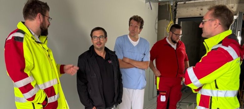 Notarzt Dr. Christian Körner (von links) erläutert gemeinsam mit Bereichsleiter Greb die Vorteile des Standortes, den Landrat Dr. Mischak (von rechts), Notfallsanitäter Benedikt Geiger und Dr. Martin Grapengeter, Chefarzt Anästhesiologie und Intensivmedizin am Krankenhaus Eichhof, inspizieren.