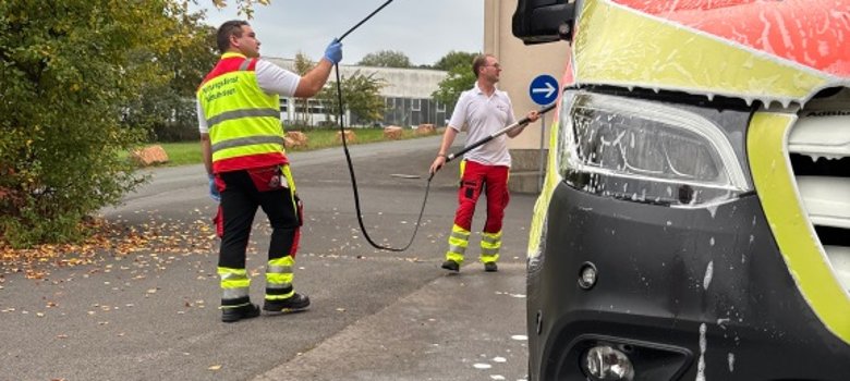 Wöchentlicher Pflichttermin: Landrat Dr. Mischak (rechts) und Rettungssanitäter Michael Döll bei der Fahrzeugpflege.
