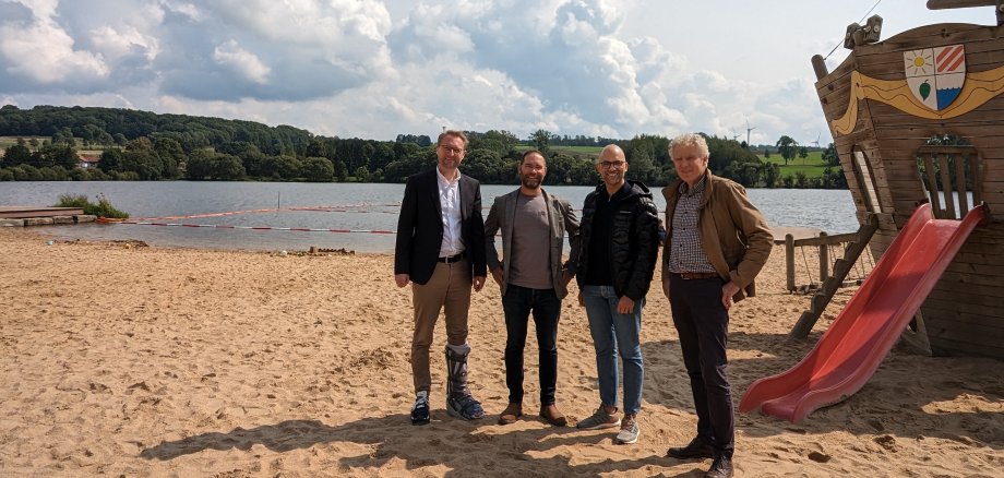 Der Erste Kreisbeigeordnete Dr. Jens Mischak (links), beim Besuch am Nieder-Mooser See. Dort trifft er gemeinsam mit Lorenz Kock (rechts), stellvertretender Leiter des Amts für Wirtschaft und den ländlichen Raum, unter anderem Daniel Heitzenröder (von rechts), Geschäftsführer der Camping Heitzenröder GmbH, und Florian Appel, Geschäftsführer der Erlebnis- und Freizeitwelt Nieder-Mooser See. 