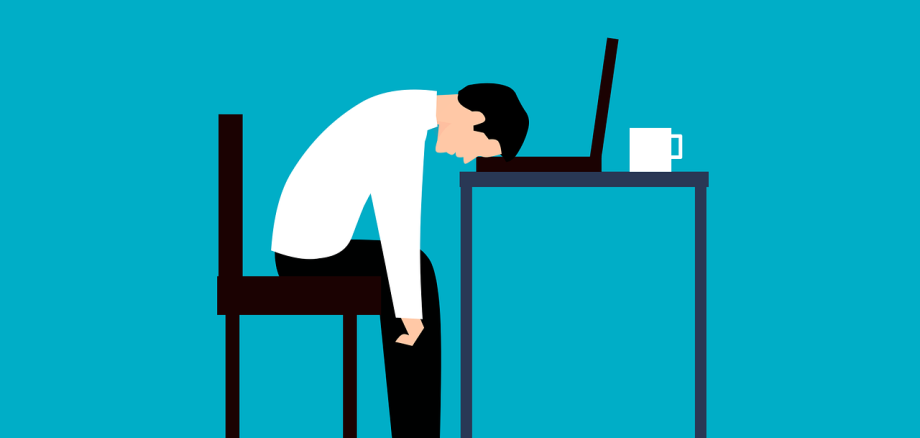 Illustration von einem Angestellten, der erschöpft seine Stirn auf einen Laptop auf einem Tisch gelegt hat. 