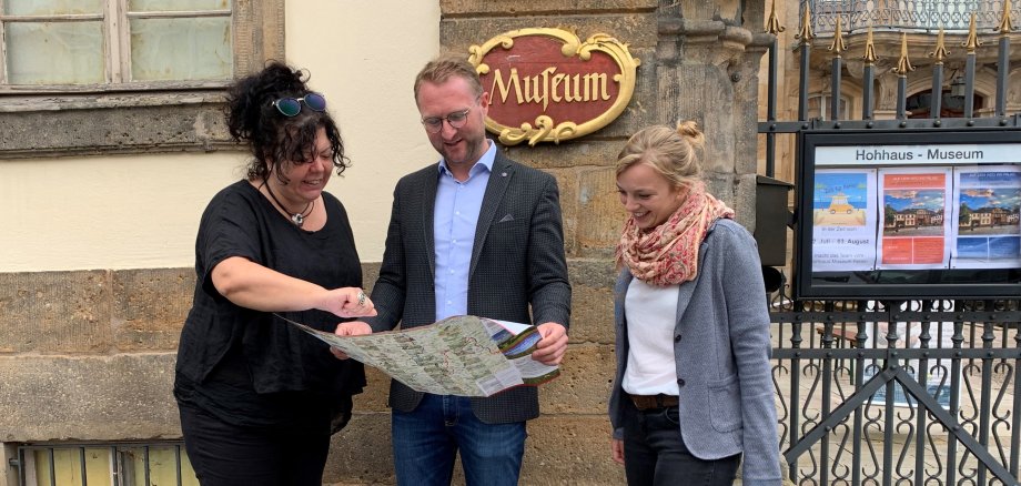 Petra Schwing-Döring, Dr. Jens Mischak und Felicitas Fait schauen sich gemeinsam eine Ausflugskarte an