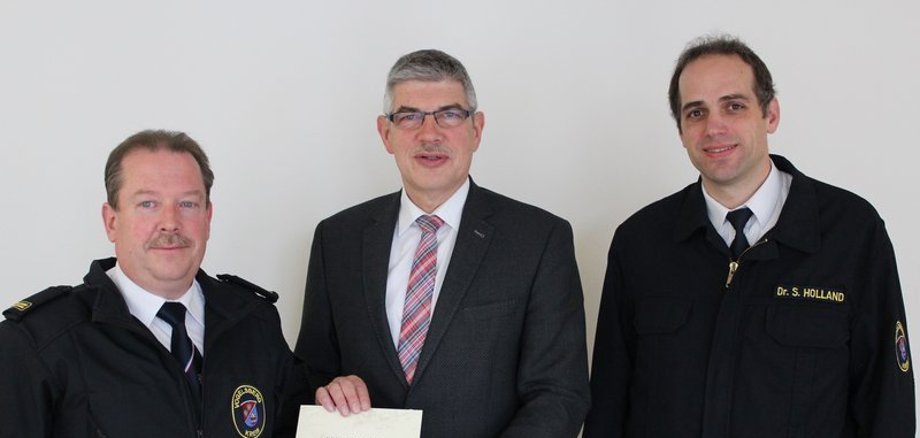 Drei Männer präsentieren die Ernennungsurkunde. Mit Hubert Helm (links) hat Kreisbrandinspektor Dr. Sven Holland (rechts) einen erfahrenen Mann an seiner Seite, der von Landrat Manfred Görig erneut zum Kreisbrandmeister und zum stellvertretenden Kreisbrandinspektor ernannt wurde.