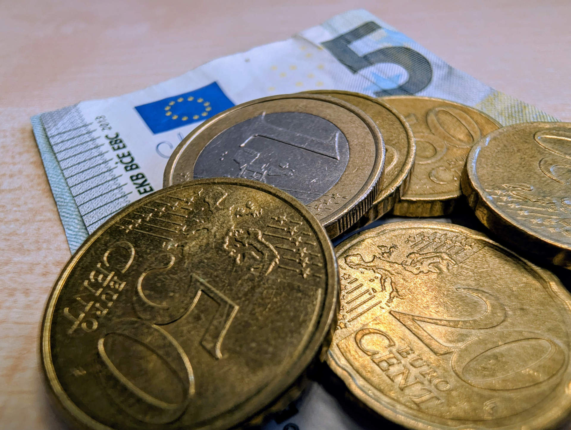 Nahaufnahme von Kleingelt. Darauf sind Euromünzen und ein 5-Euro-Schein zu sehen.