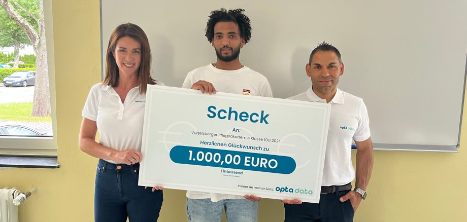 Glücklicher Gewinner: Solomon Tsegay Tesfay (Mitte) gewann 1000 Euro bei einem Gewinnspiel der Firma „opta data“  für seinen Kurs an der Vogelsberger Pflegeakademie. Rebecca Felske und Tony Altimari (beide „opta data“) freuten sich,  den Scheck nun zu überreichen.                                                                                
