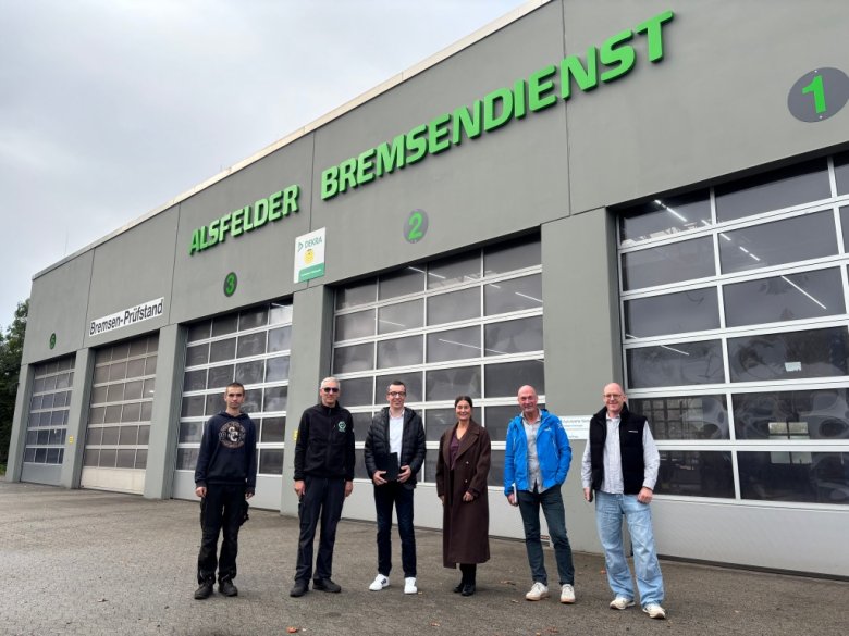 Patrick Krug (dritter von links), Erster Kreisbeigeordneter sowie Schul- und Sozialdezernent, sowie Lars Kersten (von rechts), Lehrer an der Brüder-Grimm-Schule in Alsfeld, Michael Dippel, Werkstattleiter von Kompass Leben e.V. Katja Diehl, Vorstandsvorsitzende von Kompass Leben e.V., und Stefan Riegelmann, Inhaber vom Fahrzeugservice Riegelmann Alsfelder Bremsendienst, gemeinsam mit Jan, der seit Februar im Unternehmen mitarbeitet.