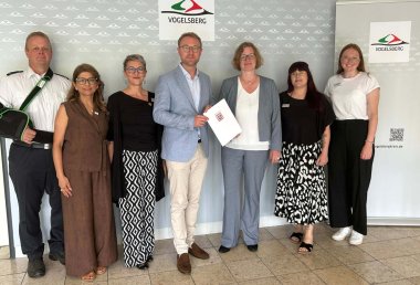 Staatssekretärin und Landrat mit (von links) Björn Preuß-von Brincken, Interkultureller Berater Feuerwehr und Projektpartner, Nazila Afshar, Saskia Heister, Antonia Schäfer und Sina Schmidt vom WIR-Vielfaltszentrum.