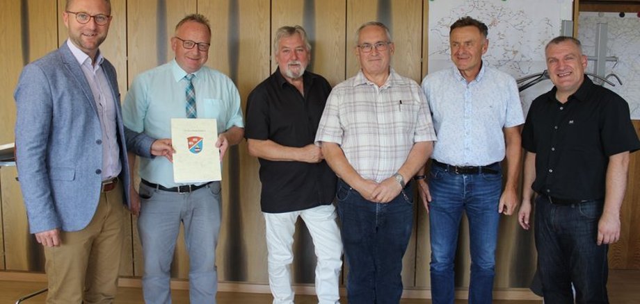 Erster Kreisbeigeordneter Dr. Jens Mischak überreicht Bürgermeister Dieter Schäfer den Bewilligungsbescheid für die Einrichtung des Rundwanderweges „Sieben-Dörfer-Tour“. An der Umsetzung beteiligt sind: Hubert Straub und Reiner Seibert vom Projektteam, Thomas Schaumberg, Geschäftsführer der Vogelsberg Consult, und Peter Sukdolak aus dem Sachgebiet Dorf- und Regionalentwicklung (von links).