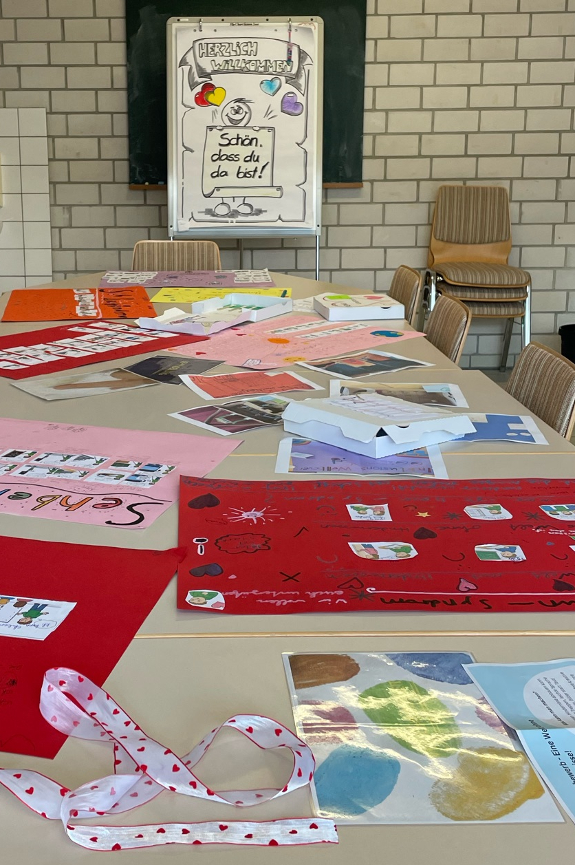 Ein Tisch mit vielen von Kindern gestalteten Plakaten zum Thema Inklusion