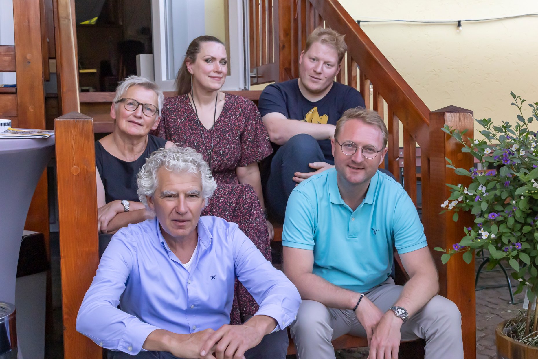 (hinten v. l). Gudrun Stumpf, Elisabeth Eisenbarth, Sebastian Heil, (vorne v. l.) Lorenz Kock (Projektleitung im Amt für Wirtschaft und den ländlichen Raum) sowie Jurymitglied Dr. Jens Mischak haben weitere Vogelsberg ORIGINAL-Produkte ausgezeichnet. Sie sitzen auf einer Holztreppe und schauen in die Kamera