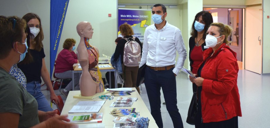 Tabassom Abiri, Cornelia Krömmelbein und René Lippert stehen am Informationsstand der Krankenpflegeschule des Vogelsbergkreises