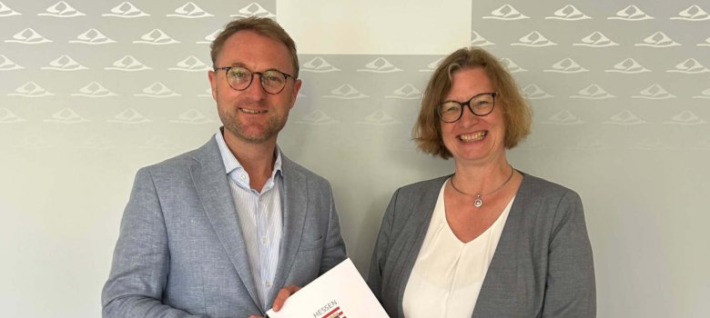 Staatssekretärin Katrin Hechler übergibt Landrat Dr. Jens Mischak den Förderbescheid. 