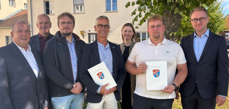 Landrat Dr. Jens Mischak (vorne, von rechts) übergibt Landschaftsgärtnermeister Felix Ruhl von „Garten Ruhl“ aus Herbstein, und Uli Auer, Leiter der Tischlerei und Vertreter der Werkstattleitungen, sowie Marc Wagner, ebenfalls in der Tischlerei tätig, und unter anderem für Maschinen und Ausbildung zuständig, die Förderbescheide. Auch Edwin Schneider (hinten, zweiter von links), Vorsitzender des LEADER-Beirats, Matthias Steckenreuter (links), Regionalmanagement im Verein Region Vogelsberg, und Jana Brittner, Sachgebietsleiterin der Bewilligungsstelle im Amt für Wirtschaft und den ländlichen Raum, wünschen den beiden Projekten alles Gute.
