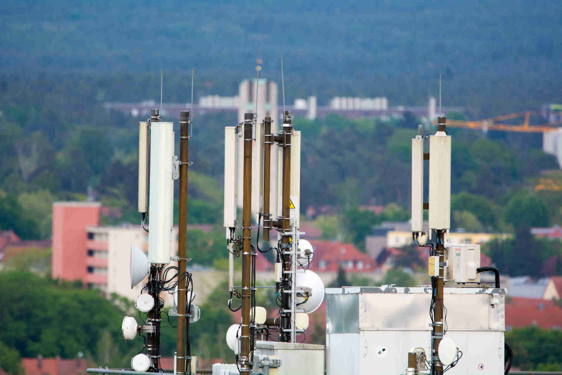 Auf dem Bild sind mehrere Mobilfunkantennen auf einem Dach zu sehen.