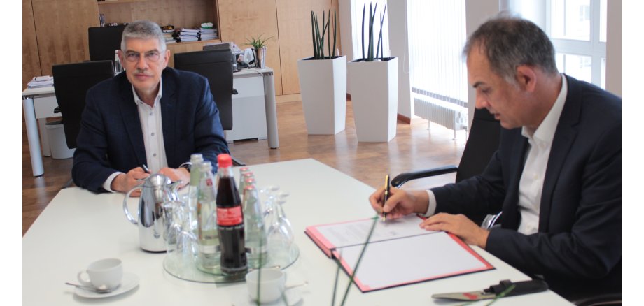 Volker Röhrig, neuer Geschäftsführer des Kreiskrankenhauses in Alsfeld, unterzeichnet im Beisein von Landrat Manfred Görig, dem Aufsichtsratsvorsitzenden der Krankenhaus GmbH, seinen Vertrag. 