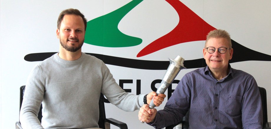 Präsentieren die olympische Fackel, die am 13. Juni vor dem Start des Mehrgenerationenlaufs entzündet wird: Sportkoordinator Dominic Günther (links) und der Kommunale Behindertenbeauftragte Hans-Jürgen Röhr. 