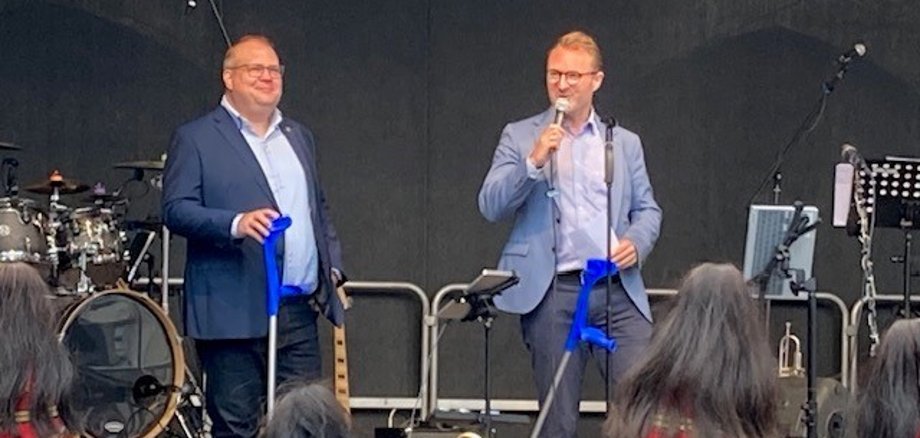 Dr. Jens Mischak (rechts), Erster Kreisbeigeordneter und Vorsitzender des Vereins Kulturförderung Vogelsberg sowie Stephan Paule, Bürgermeister der Stadt Alsfeld und Vorstandsmitglied im Verein Kulturförderung Vogelsberg, eröffneten auf der Bühne am gemeinsam das Vulkansommer-Kulturfestival am Alsfelder Marktplatz. 
