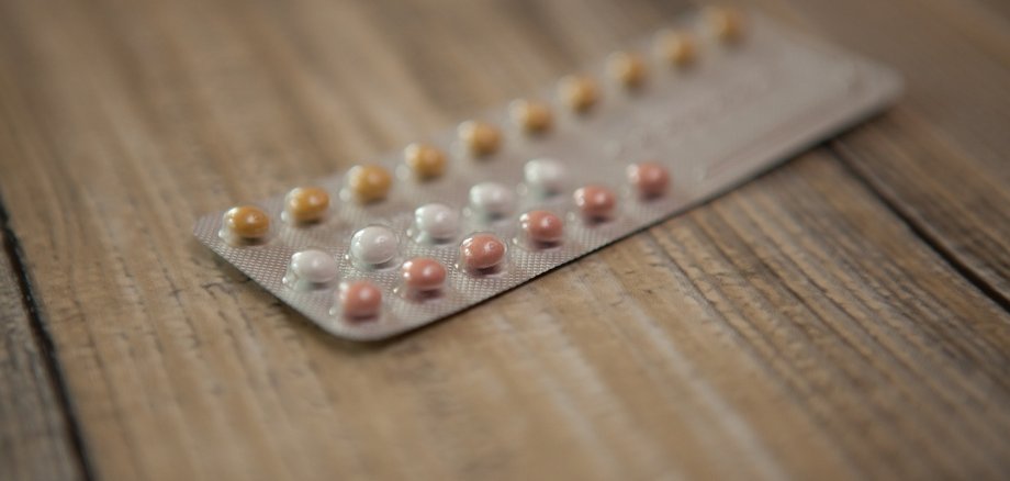 Ein Blister mit Verhütungsmitteltabletten auf einem Holztisch