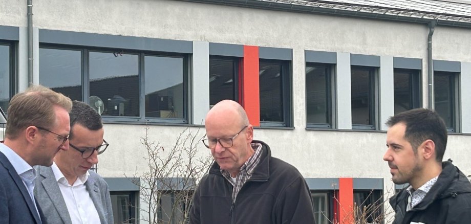 Landrat Dr. Jens Mischak und Erster Kreisbeigeordneter Patrick Krug lassen sich von Jürgen Henke, der den Einbau der Anlage maßgeblich von Seiten des Amtes für Hochbau, Energie und Gebäudewirtschaft begleitet hat, und Klimaschutzmanager Marcel Pfeil, der die gesamte Eine-Millionen-Investitionsoffensive verantwortlich betreut, die technischen Daten der neuen PV-Anlage vorstellen.