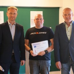 Landrat Dr. Jens Mischak, Vorstandsvorsitzender des Vereins Region Vogelsberg, und Edwin Schneider (rechts), Vorsitzender des LEADER-Beirats, überreichen Mittel für ein Wassermessgerät an Sebastian Rau vom Sportanglerclub Romrod.