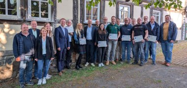 Landrat Dr. Jens Mischak (vorne, Fünfter von links), Vorstandsvorsitzender des Vereins Region Vogelsberg, und Edwin Schneider (Zweiter von links), Vorsitzender des LEADER-Beirats, gemeinsam mit Vertreterinnen und Vertretern der Vereine und Kommunen sowie des LEADER-Regionalmanagements bei der Übergabe der Zuwendungsverträge am Herbsteiner STATT-Museum.